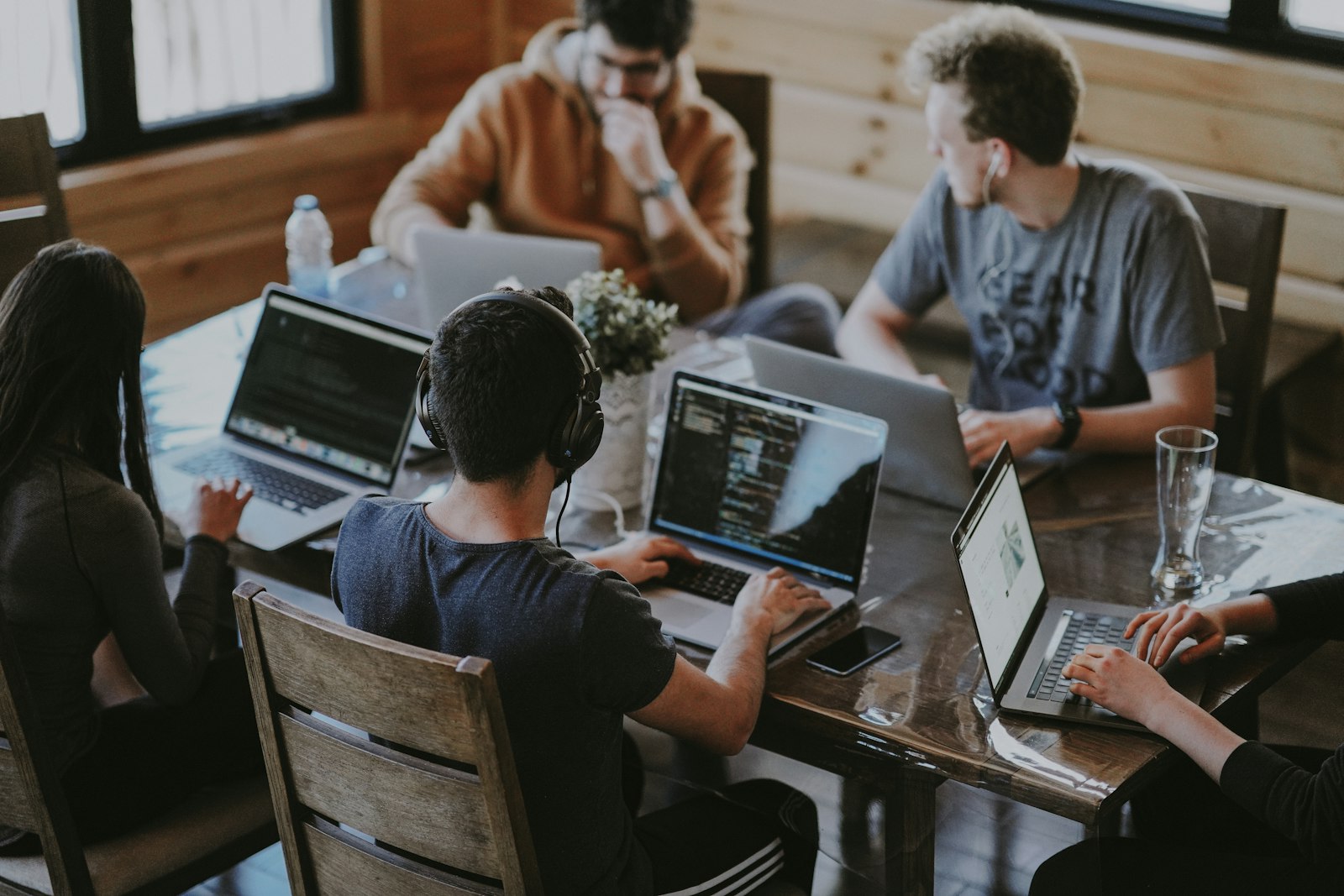 An agency team collaborating around a laptop on client mobile app projects