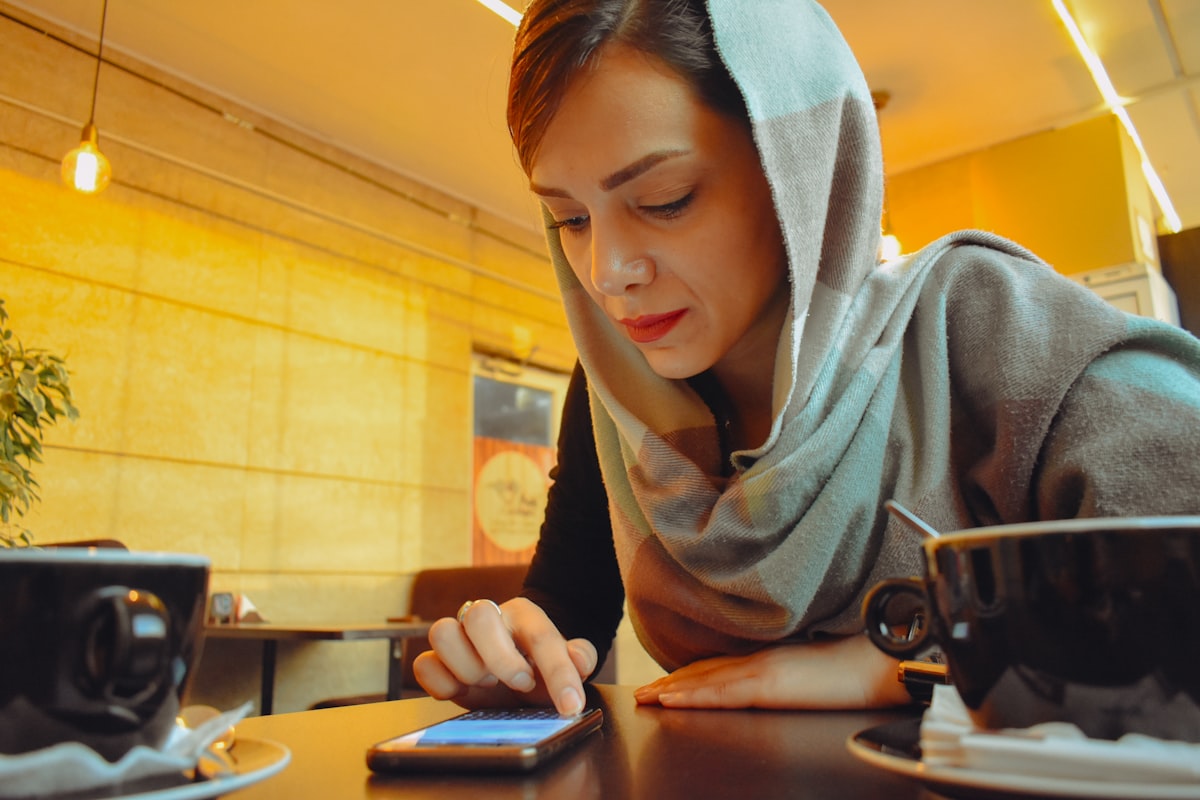 Woman receiving alert on mobile phone at cafe
