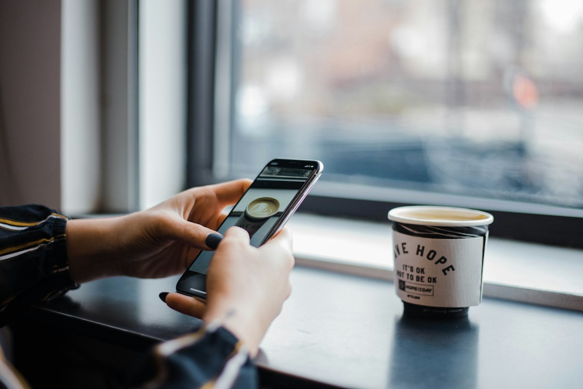 Person using smartphone app in coffee shop